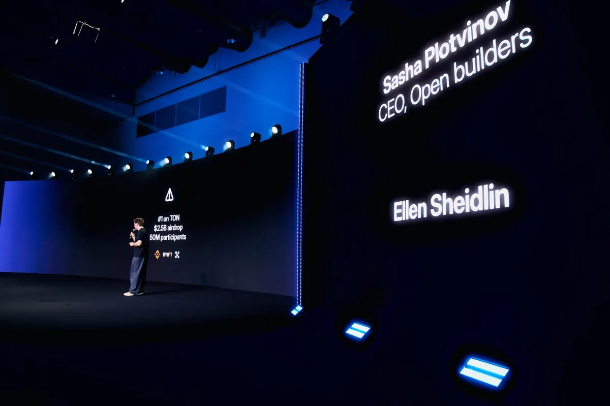 Speaker presenting at a showroom event in Dubai beside large presentation screens